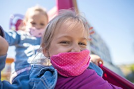 Mädchen mit Halstuch vor dem Mund