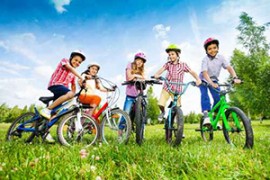 Kinder mit bunten Helmen auf ihren Fahrrädern Kinder mit bunten Helmen auf ihren Fahrrädern