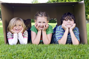 Kinder im Karton auf der Wiese
