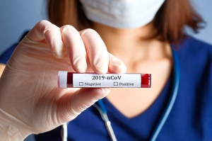 FAQ zu Antigen-Schnelltests Frau mit COVID Teströhrchen