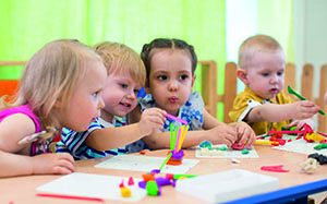 Kindergartenkinder spielen am Tisch